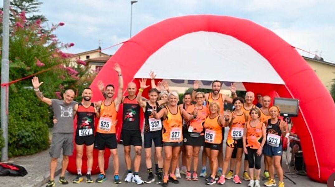 Gruppo di runner con pettorale sotto l’arco di partenza