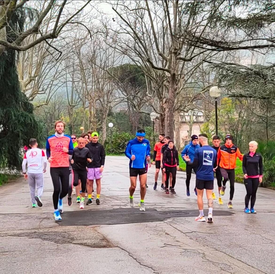 Allenamento di gruppo lungo un viale alberato